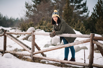 Woman with hat resting on a wooden fence