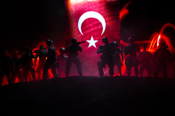 Silhouette of soldier with rifle against a turkish flag. Selective focus