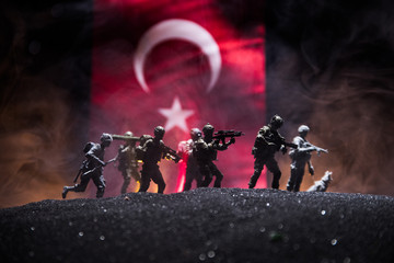 Silhouette of soldier with rifle against a turkish flag. Selective focus