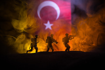 Silhouette of soldier with rifle against a turkish flag. Selective focus