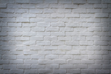 Abstract empty cracking white bricks stone wall with soft light and shadow as a frame for background or wallpaper and product display.