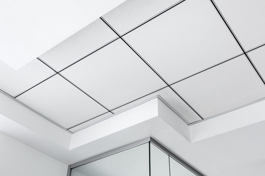 multi-level ceiling with three-dimensional protrusions and a suspended tiled ceiling white color, close up geometric details.