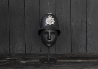 british police helmet on black wooden background