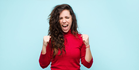 young pretty woman shouting aggressively with annoyed, frustrated, angry look and tight fists,...