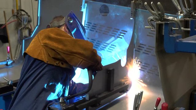A welder welding an assembly using a fixture or jig.