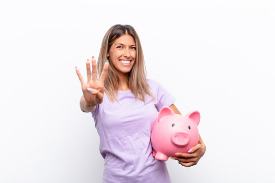 Young Pretty Woman Smiling And Looking Friendly, Showing Number Three Or Third With Hand Forward, Counting Down With A Piggy Bank.