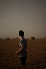 silhouette of man standing on the field at sunset