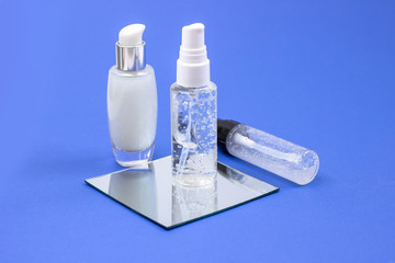 Cosmetic bottles with serum, gel, face cream on a blue background. Skin cosmetics, minimalism. The...