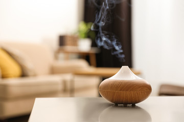 Aroma oil diffuser on light table at home, space for text. Air freshener