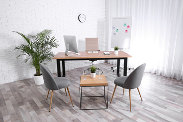 Interior of modern office with table, chairs and computer
