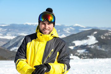 Fototapeta na wymiar Happy young man in mountains. Winter vacation