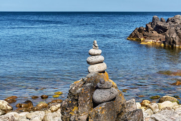 Stacked pebbles at the beach of Helligdomsklipperne (Sanctuary Cliffs) in the vicinity of Gudhjem, Bornholm island, Denmark.