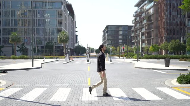 Side view of confident businessman passing crosswalk in modern district of megalopolis