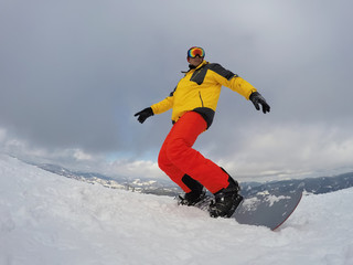 Fototapeta na wymiar Man snowboarding at ski resort. Winter vacation
