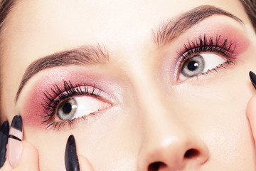 Obraz premium Portret dziewczynki z długimi paznokciami, zbliżenie dziewczyny z różowymi cieniami, profesjonalne brwi. Piękne brwi.