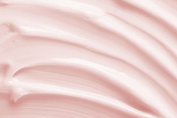 Beauty cream texture background. Pink color cosmetic cream lotion moisturizer smear. Skin care product  strokes closeup