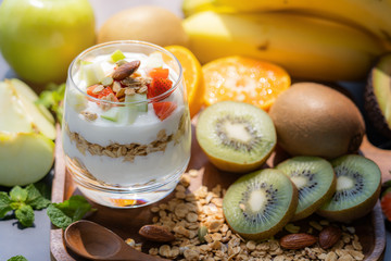 Plain yogurt with fresh fruits and granola on top in glass.Healthy food