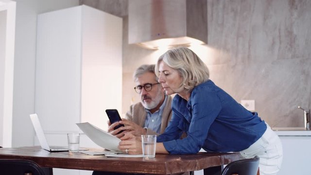 Slow motion shot of mature couple photographing contracts