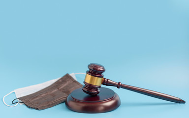  brown gavel and medical protective masks on a blue background