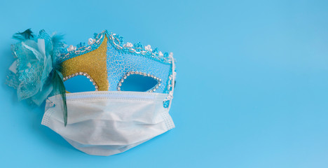 carnival mask in a protective medical mask on a blue background