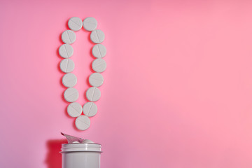 Pharmaceutical.The exclamation mark of the pills.Exclamation point. White pills on a pink background. Important information on medical topics. Copy space.