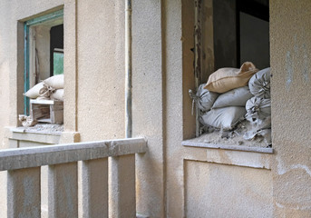 Sandbags piled up at a window of a house in the buffer zone 