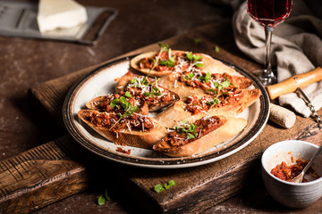 Italian bruschetta with olive paste, parmesan cheese and fresh oregano leaves. Rustick, wooden background.