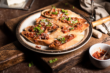 Italian bruschetta with olive paste, parmesan cheese and fresh oregano leaves. Rustick, wooden background.
