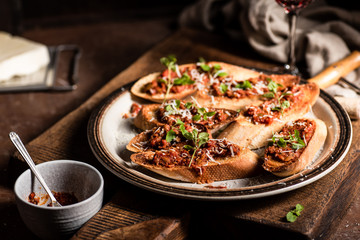 Italian bruschetta with olive paste, parmesan cheese and fresh oregano leaves. Rustick, wooden background.