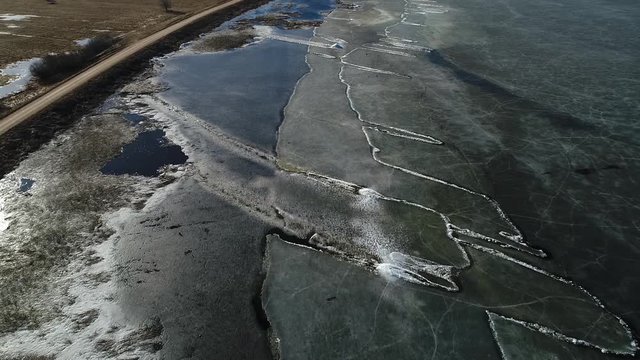 Moving ice plates in spring on lake Burtnieks ice shove aerial view