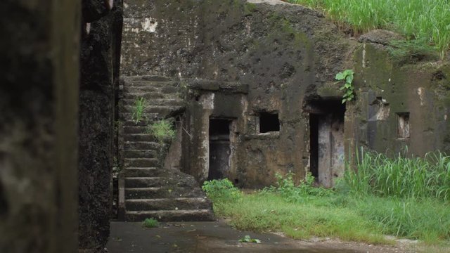 Foreground wipe reveals a war torn bunker on Corregidor Island.