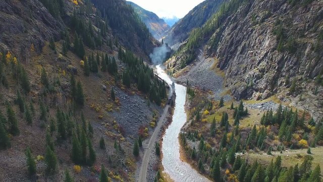 Steam train travels through a river canyon