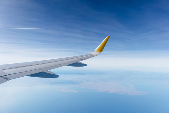ala de avi&oacute;n de pasajeros airbus a320 sobrevolando el delta del ebro (catalu&ntilde;a, espa&ntilde;a), con el cielo zul nublado de fondo.