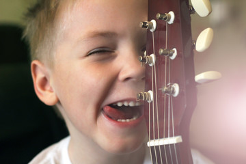 Positive boy child and guitar, cheerful portrait