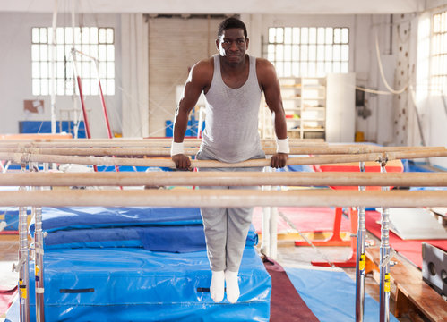 man in sportswear doing exercises on parallel bars