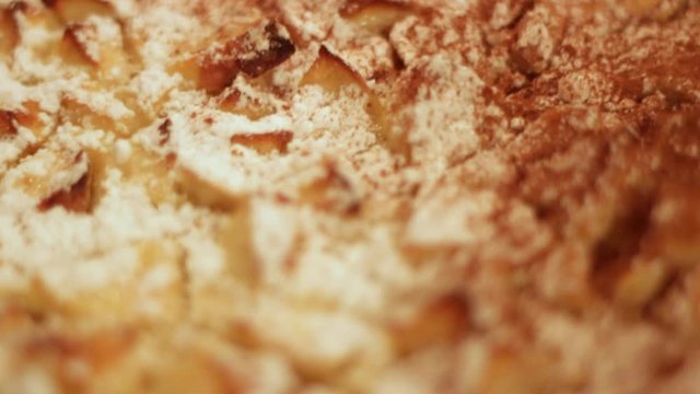 Traditional sugary apple cake detail texture, soft focus handheld shot