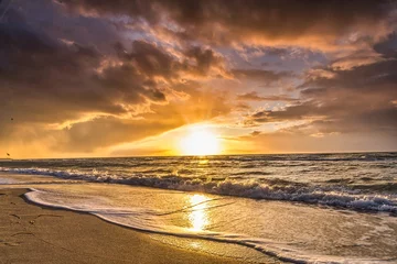 Foto auf Glas Farbiger Sonnenuntergang mit Wolkendecke über dem Sonnenuntergang am Strand - dramatischer Sonnenuntergang an der Ostsee © Riko Best