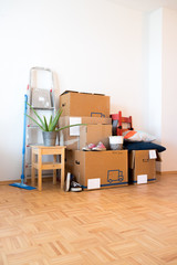 Fototapeta premium Move. Cardboard boxes, cleaning things and stuff for moving into a new, clean and bright home. Text space.