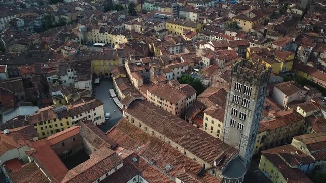 Aerial pan up reveal renaissance tuscany lucca city with high bell church tower
