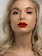 Closeup portrait of a woman with developing straight hair. Sweet tender young girl blonde. Red lipstick, transparent clean skin. Skin care natural cosmetics in the spa salon or cosmetology.