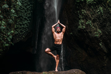 A man of athletic build does yoga. Healthy lifestyle. The concentration of the body. A man does...