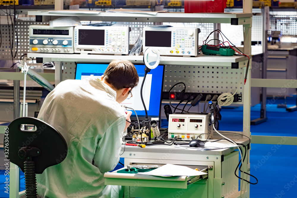 Poster man in a technology laboratory. man with a soldering iron at the desk. concept - modern inventor. wo
