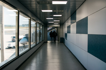 personas al final del tunel de embarque de un avión en un aeropuerto