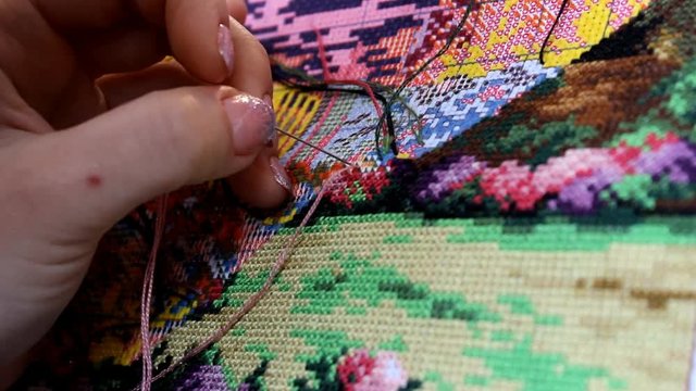 Cross stitch handmade process. Printed canvas embroidery