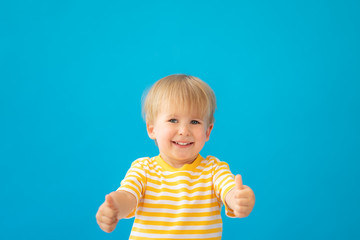 Happy child wearing striped shirt against blue background