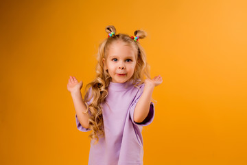 portrait of a happy child girl isolate on a yellow background, space for text