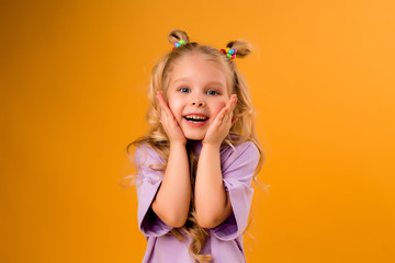 portrait of a happy child girl isolate on a yellow background, space for text