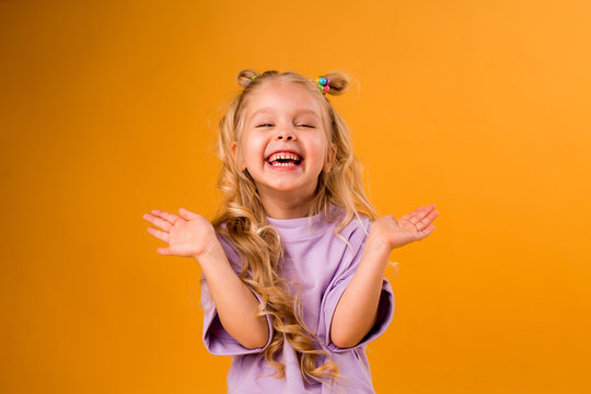 portrait of a happy child girl isolate on a yellow background, space for text