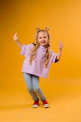 portrait of a happy child girl isolate on a yellow background, space for text