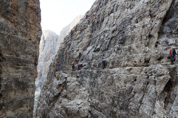 People climbing the Via Ferrata Sentiero delle Bocchette Alte in Brenta Dolomites mountains, Italy